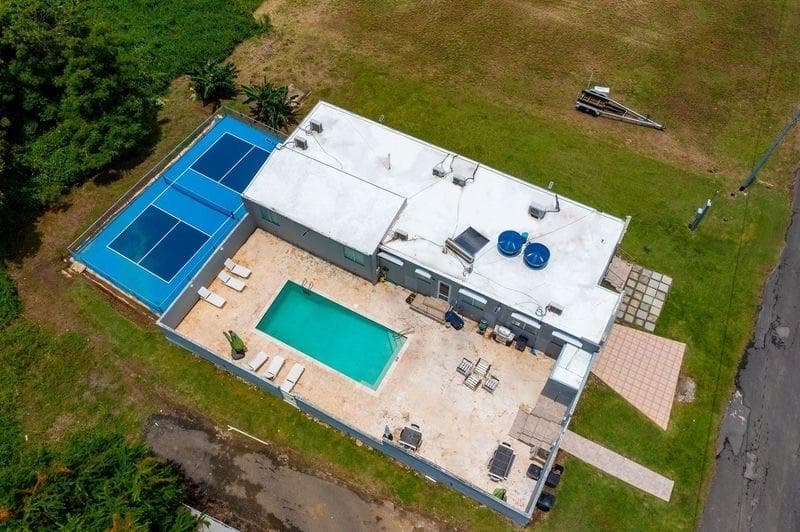 Aerial view of the house featuring a brand new pickle ball court. Bring your balls and paddles and enjoy a match with your family and friends!